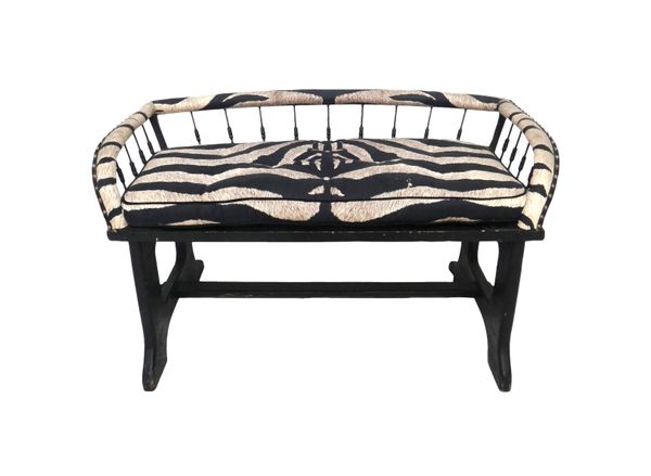 A faux zebra skin upholstered two seat bench, with splayed spindle back on dual standard ends, 105cm wide. K3Provenance- from the estate of Fleur Cowl
