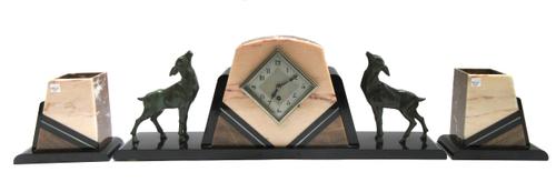 A German walnut cased mantel timepiece, late 19th/early 20th century, with white enamel dial and waisted case, with metal foliate embellishments, the