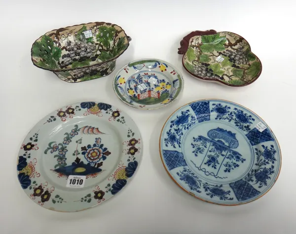 A Lambeth delftware polychrome plate, mid-18th century, painted with flowering shrubs issuing from a blue mound, 23cm diameter; also two Dutch Delft p