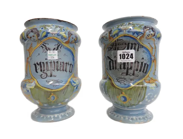 A pair of Italian tin glaze drug jars, late 19th century, detailed 'diappio' and 'rqipiaro', each with a shaped cartouche flanked by winged angels, ag