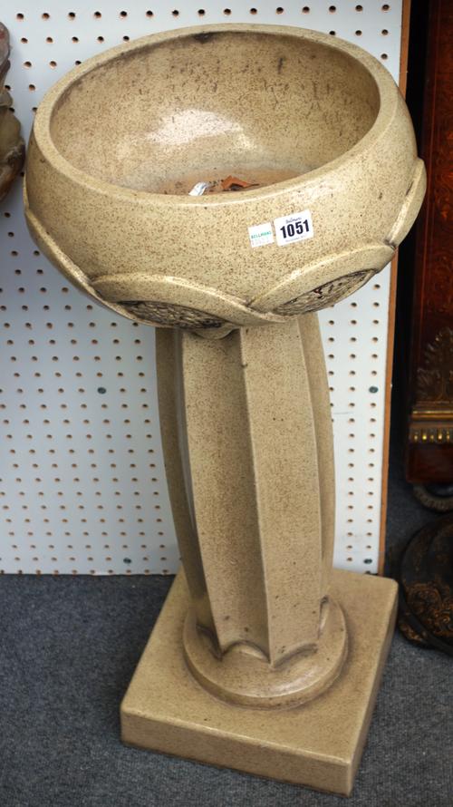 A pair of Art Nouveau stoneware jardinieres and stands, circa 1920, each decorated with a intertwined band, over a fluted central column and square fo