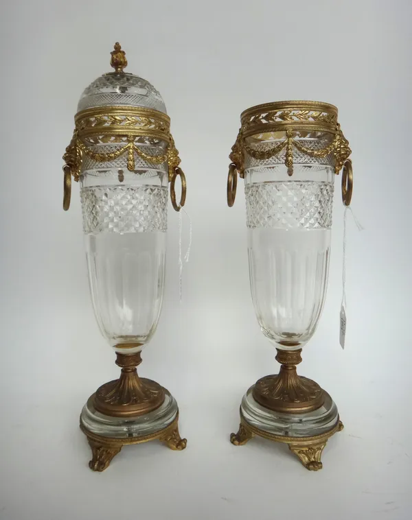 A pair of early 20th century French gilt bronze mounted cut glass garniture vases, the glass possibly St Louis, (lacking one cover), 37cm high. (2)
