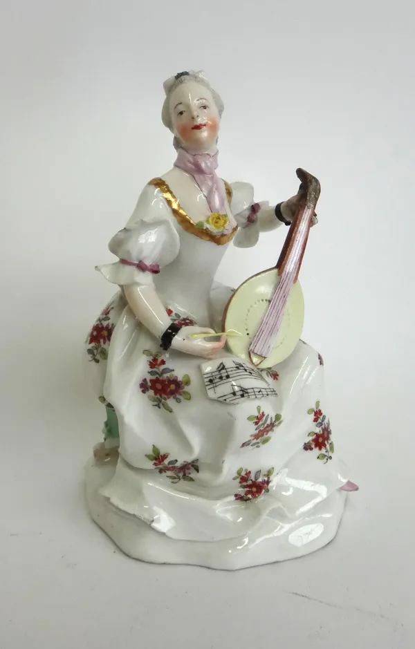 A Vienna figure of a lady playing a mandolin, circa 1770, blue shield mark, modelled with sheet music on her knee, on a naturalistic base, 16cm high (