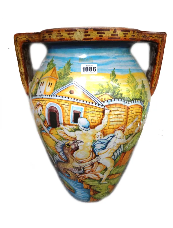 An Italian maiolica twin handled vase, late 19th century, depicting four male nudes engaging a mythological dragon, against an architectural backdrop,