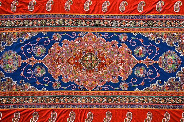 A large embroidered hanging, Rescht, Persia, 20th century, the main deep blue field with central lobed medallion with polychrome floral design, simila