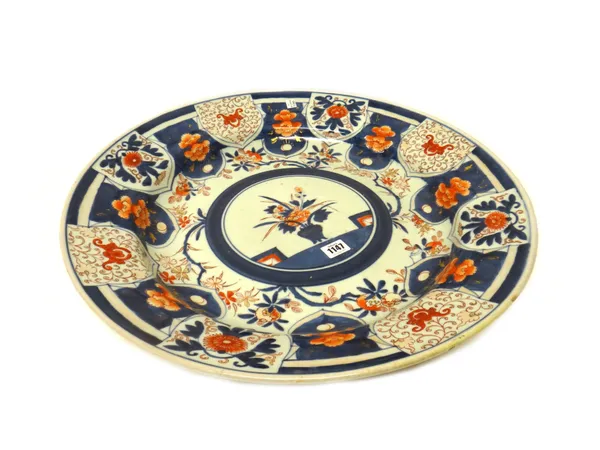 A large Japanese Imari dish, Edo period, painted in the centre with a vase of flowers, inside branches of pomegranates, the border with lappets enclos