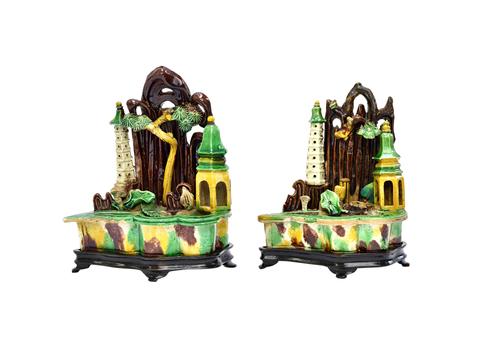 Two Chinese biscuit porcelain brushwashers, Kangxi, each modelled with two pagodas and a pine tree before a mountain, a lotus plant sprouting up from