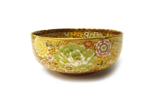 A small Japanese Satsuma bowl, early 20th, the exterior and interior painted with densely packed flowers beneath a notched rim, signed, 12cm. diameter