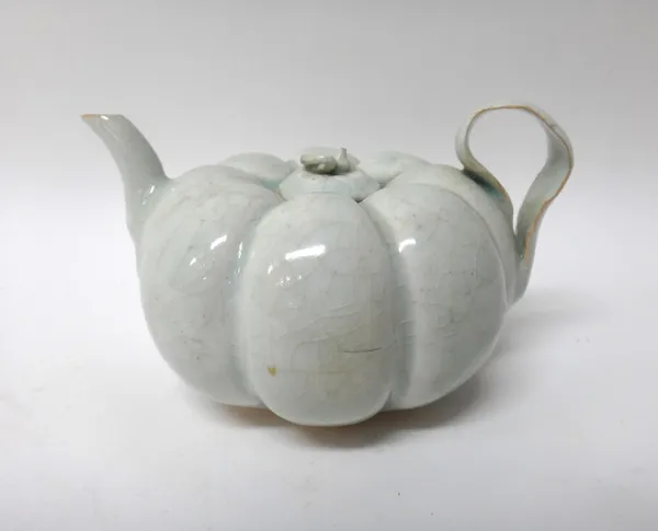 A Chinese Qingpai teapot and cover, Song dynasty or later, of melon form with strap handle, covered in a light blue glaze, 8.25cm. overall height.