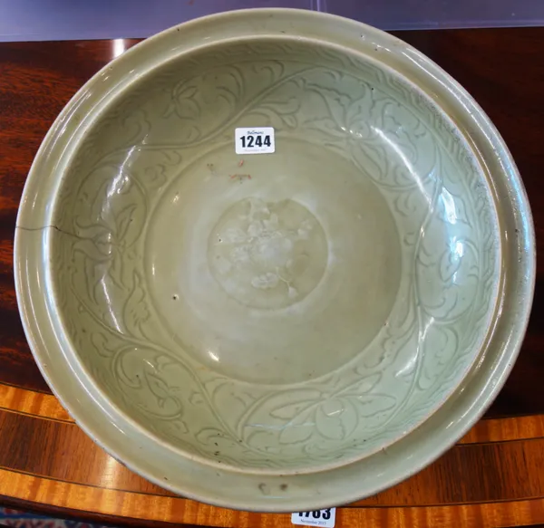 A large Chinese Longquan celadon deep dish, Ming Dynasty, the curving walls incised with lotus flowers and leafy branches around a central flower pane