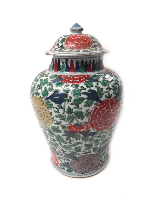 A Chinese wucai vase and cover, 17th century, of baluster form, painted with flowering peony and chrysanthemum beneath a stiff leaf border, (a.f), 38c