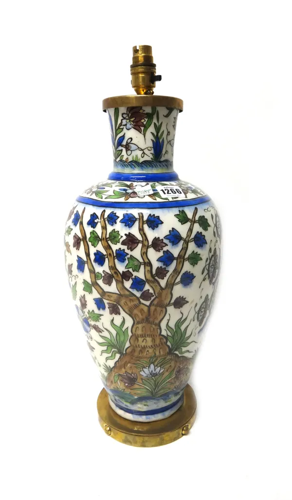 A Qajar pottery vase, late 19th/20th century, densely decorated with trees and flowers with further floral bands at the neck, fitted for electricity,