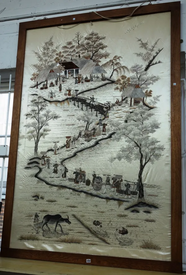 A large Chinese embroidered silk panel, 20th century, depicting a farmer and ox and rice cultivation, below a procession of figures carrying goods alo