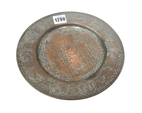 A 'Magic' tinned copper dish, Iran, probably 18th century, centred with Qur'anic script within a Zodiac sign border, 21.5cm diameter.  Illustrated