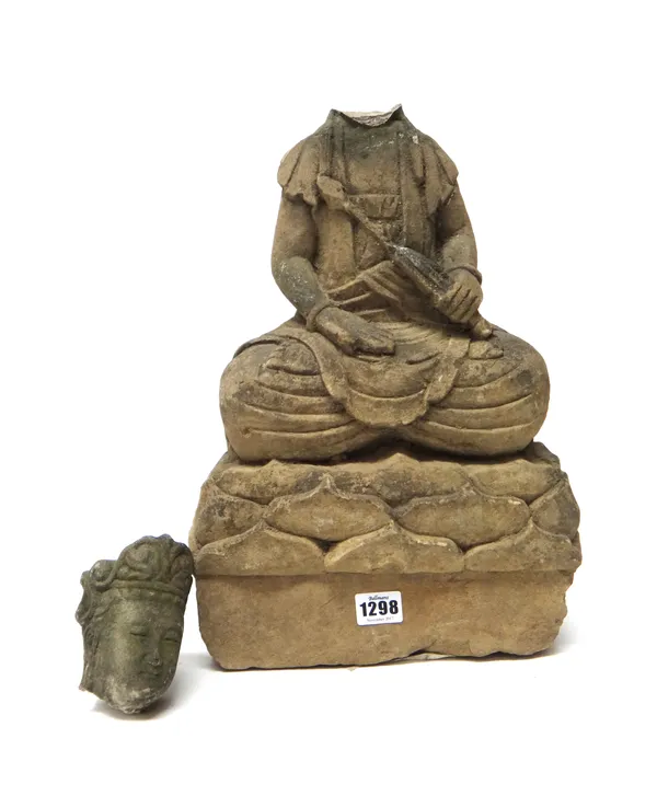 A Chinese stone figure of Buddha, Ming Dynasty, seated on a lotus base, 50cm., head detached.