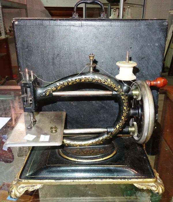 A late 19th century tabletop hand operated black and gilt painted sewing machine in an ebonised case. G7