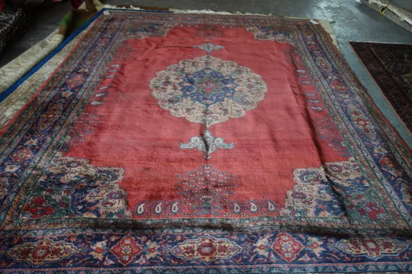 A Tabriz carpet, with central medallion and a red ground 333cm x 245cm.E3