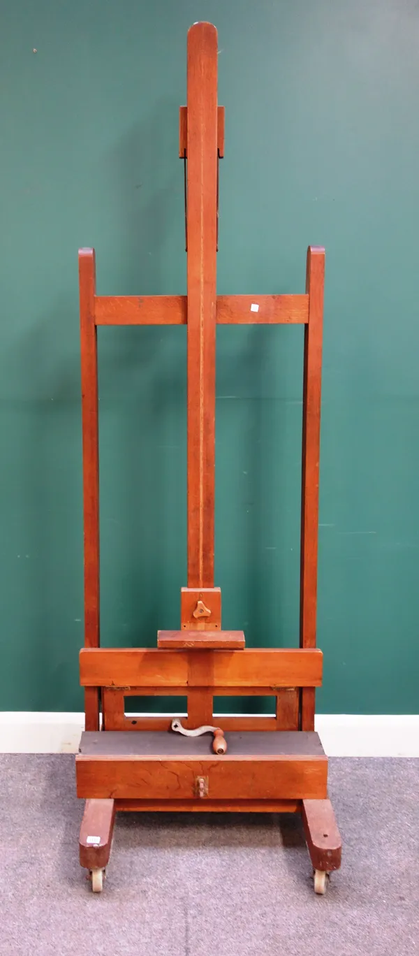 A mid-20th century oak artist's easel, with crank wind height adjustment, on trestle supports, 68cm wide.