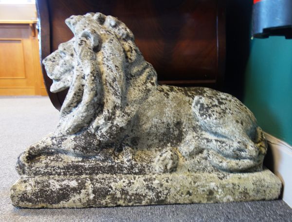 A pair of reconstituted stone figures of recumbent lions, on square bases, 72cm wide x 50cm high, (2).  Illustrated
