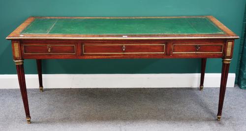 A late 18th century Baltic brass inlaid mahogany writing table, the leather inset rectangular top over three frieze drawers, on tapering fluted suppor