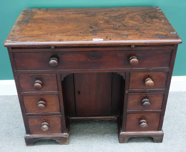A mid-18th century mahogany kneehole writing desk, with seven drawers about the cupboard, on bracket feet, 91cm wide x 77cm high x 50cm deep.