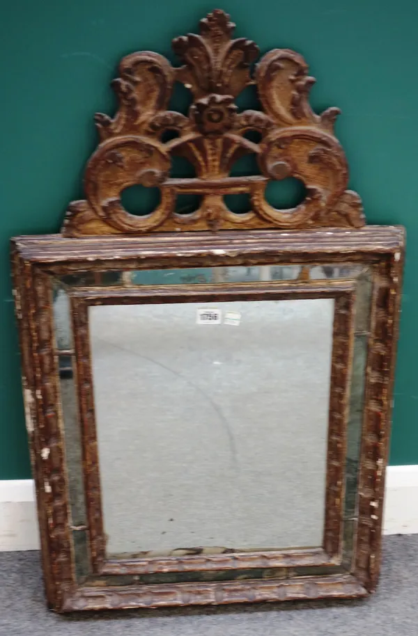 An 18th century North Italian gilt framed wall mirror, with floral carved crest over segmented rectangular frieze, 54cm wide x 90cm high.