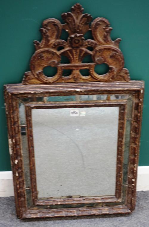 An 18th century North Italian gilt framed wall mirror, with floral carved crest over segmented rectangular frieze, 54cm wide x 90cm high.