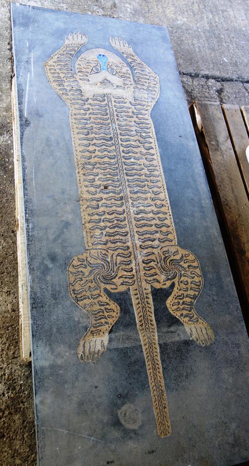 A rectangular slate table top inset with a pietra dura panel of a tiger, 80cm wide x 200cm long x 5cm deep.
