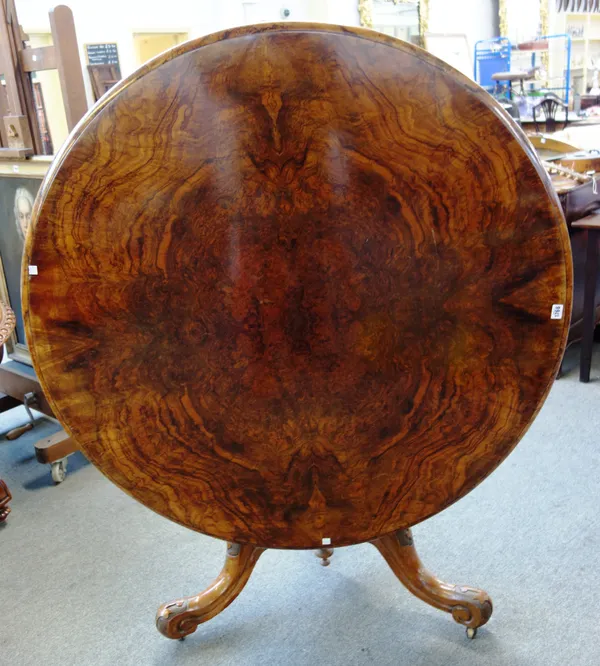 A Victorian figured walnut centre table, the circular snap top on carved tripod base, 120cm diameter x 76cm high.