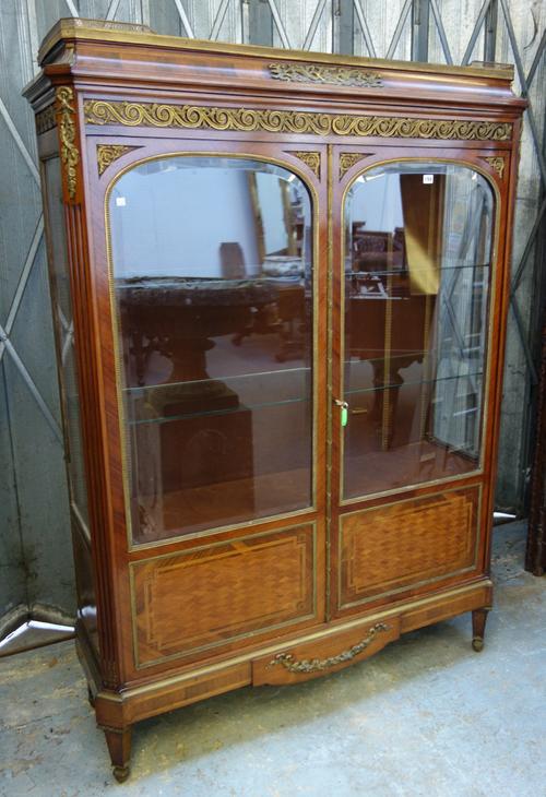 A late 19th century French ormolu mounted mahogany display cabinet, the caddy top over a pair of glazed doors, on tapering square supports, 136cm wide