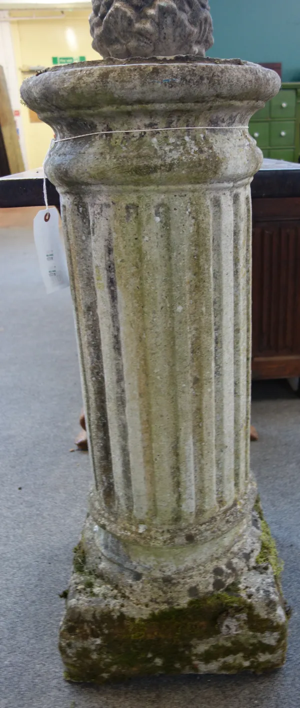 A reconstituted stone column with circular fluted body and square base, 38cm wide x 92cm high.