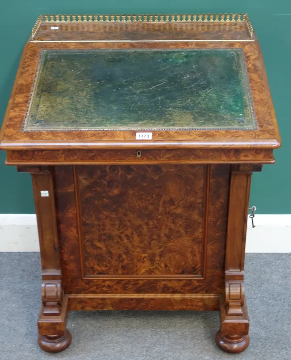 A Victorian figured walnut Davenport, the slope top enclosing a fitted interior above lockable swing out ink drawer, above panel cupboard enclosing fo