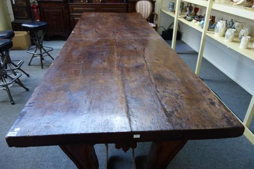 A massive 17th century and later North Italian walnut centre table, the rectangular top on four scroll supports, 99cm wide x 314cm long x 84cm high.