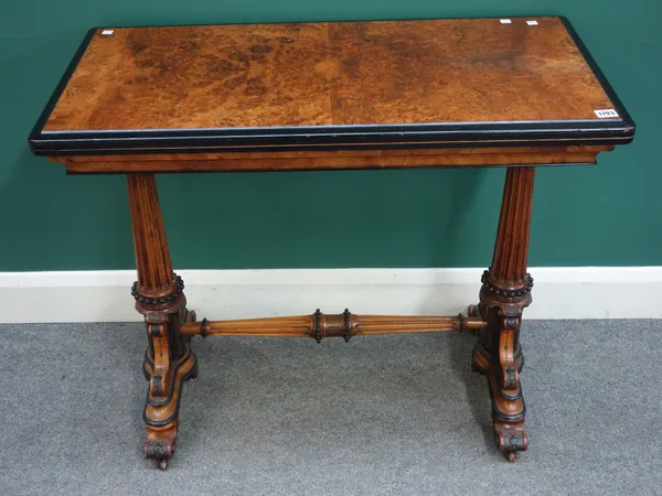 A Victorian figured walnut and ebonised card table, the rectangular fold out top on fluted supports and scroll feet, 92cm wide x 77cm high x 46cm deep