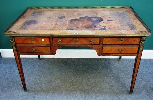 A louis XVI style gilt metal mounted faded rosewood bureau plat, the galleried rectangular top over four frieze drawers, on tapering square supports,