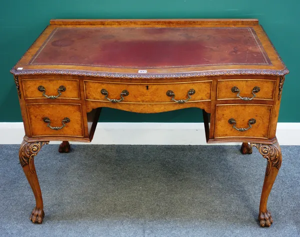A George II style figured walnut serpentine writing desk with five frieze drawers on acanthus capped cabriole supports and paw feet, 110cm wide x 77cm