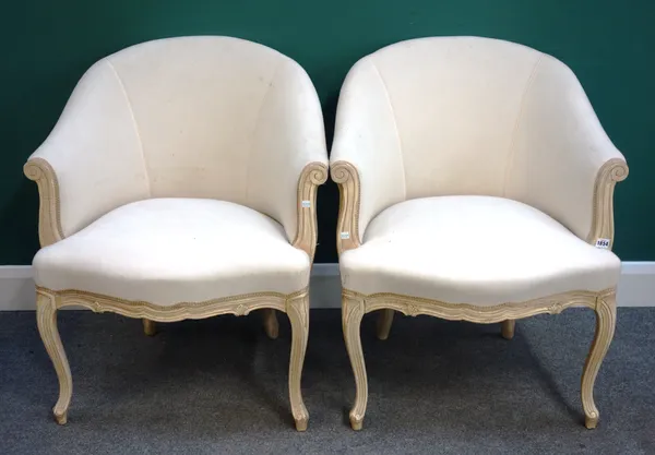 A pair of Louis XV style cream upholstered and painted tub back chairs, each with serpentine seat and scroll supports, 69cm wide x 83cm high x 65cm de