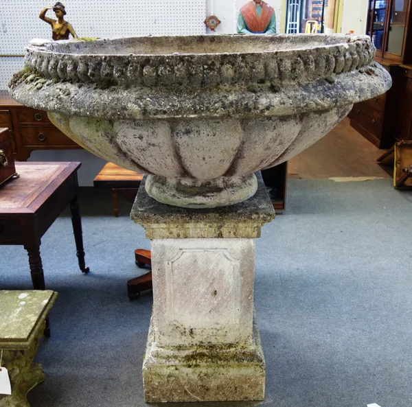 A massive pair of reconstituted stone garden urns, with shallow lobed bowls, on stepped square pedestals, 138cm diameter x 144cm high, (2).