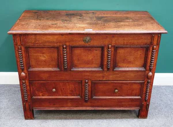 An 18th century oak mule chest, with lift top and triple panel front over a pair of drawers, 116cm wide x 84cm high x 53cm deep.