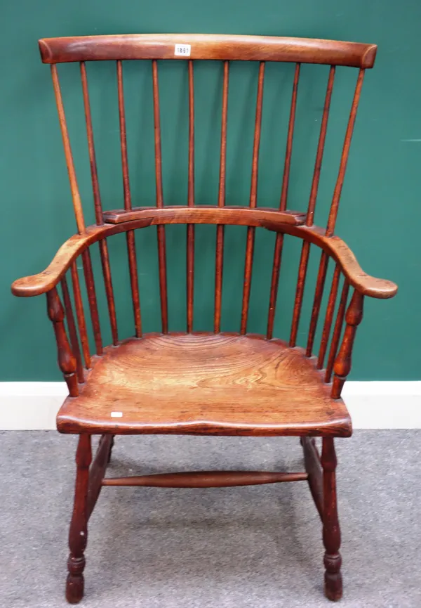 A late George III beech and elm comb back Windsor chair, with solid seat and turned supports, 70cm wide x 116cm high x 48cm deep.