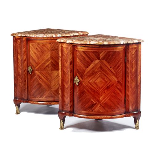 A pair of 18th century French corner cupboards, each with shaped Breche d'Alep marble top over a gilt metal mounted crossbanded kingwood bowfront sing