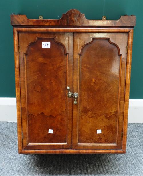 An early 20th century walnut hanging cupboard with pair of arch hanging doors, 47cm wide x 65cm high.