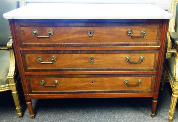 A late 18th century French commode, the shaped marble top over a mahogany three drawer base flanked by fluted columns, 114cm wide x 90cm high x 56cm d