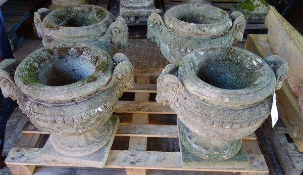 A set of four reconstituted stone jardinieres, with opposing rams head finials and leaf moulded bodies, on square bases, 52cm wide x 45cm high, (4).