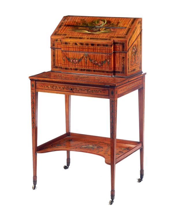 A late Victorian coromandel banded polychrome painted satinwood writing desk, the slope top with fitted interior over fold-out writing surface, two si