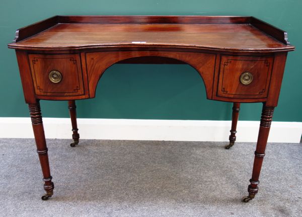 A George III mahogany concave fronted writing table with pair of frieze drawers on turned supports, 109cm wide x 81cm high x 63cm deep.