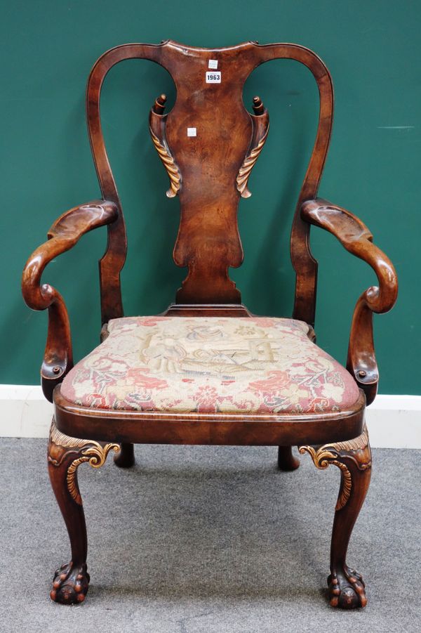 A George I style parcel gilt walnut carver chair, with scroll vase back and bow seat, on ball and claw feet, 67cm wide x 100cm high x 60cm deep.