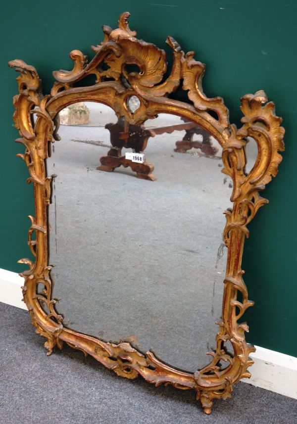 A mid-18th century Italian gilt framed wall mirror with foliate mounted 'C' scroll shaped frame, 77cm wide x 107cm high.