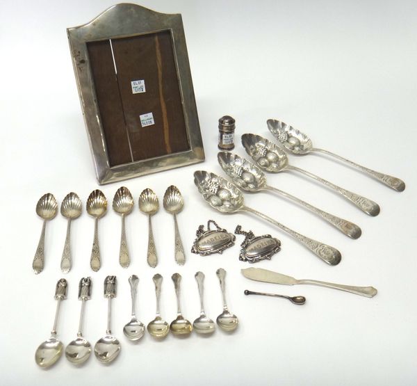 Mostly silver, comprising; a set of four berry fruit serving spoons, crest engraved, London 1823, a rectangular photograph frame, Birmingham possibly