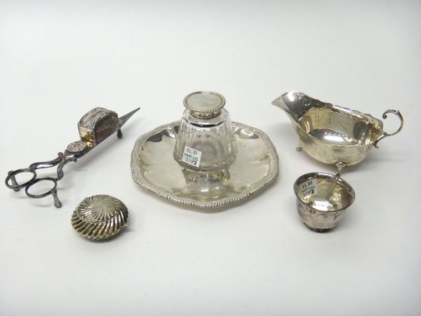 A late Victorian silver inkstand of shaped circular form, having a gadrooned rim, with a silver mounted faceted glass ink bottle of tapering design, L